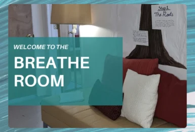 A couch with pillows sits next to a lamp and a wall display titled "Step 1 The Roots," overlaid with a sign reading "Welcome to the Breathe Room.