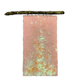 A textured, rectangular piece of pink paper with green and orange spots hangs from a twig using thin wire against a white background.